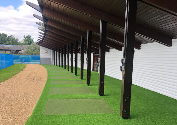 Vancouver Covered outdoor tee line with light green synthetic grass boxes inside a dark green synthetic grass strip